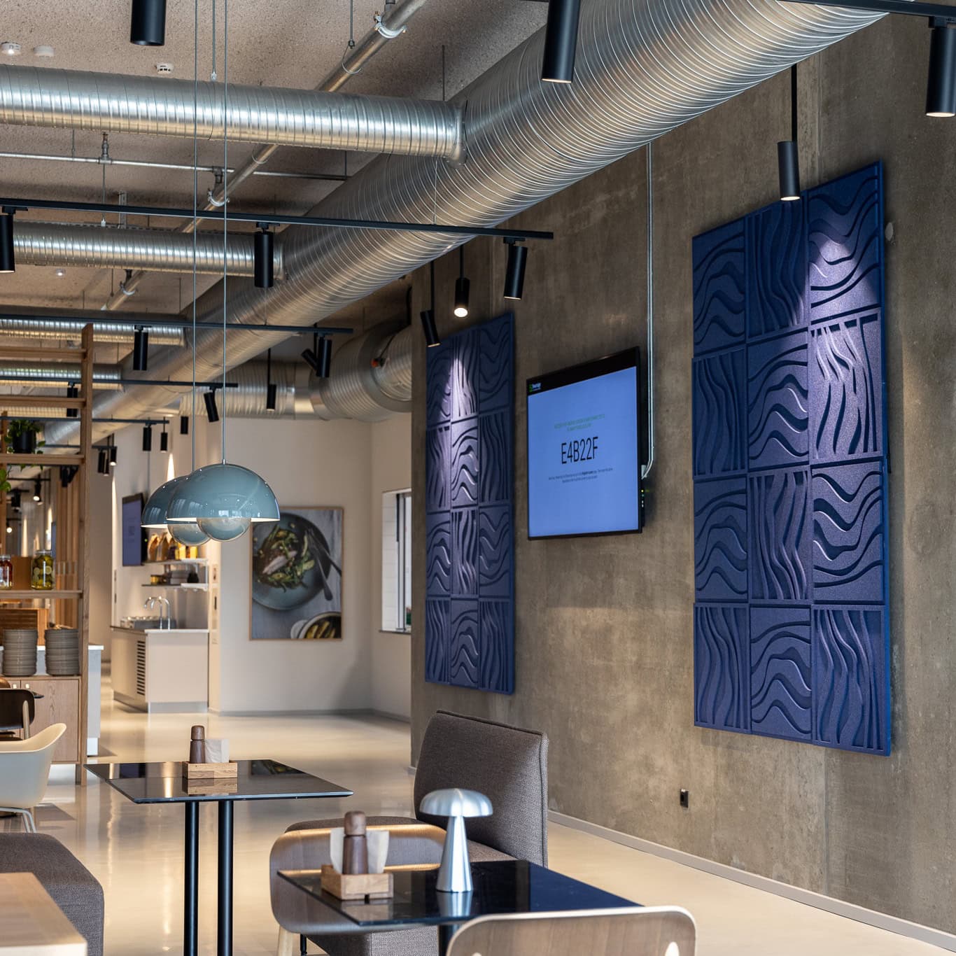 Acoustic design in the office with blue wall panels, exposed concrete wall and industrial ceiling