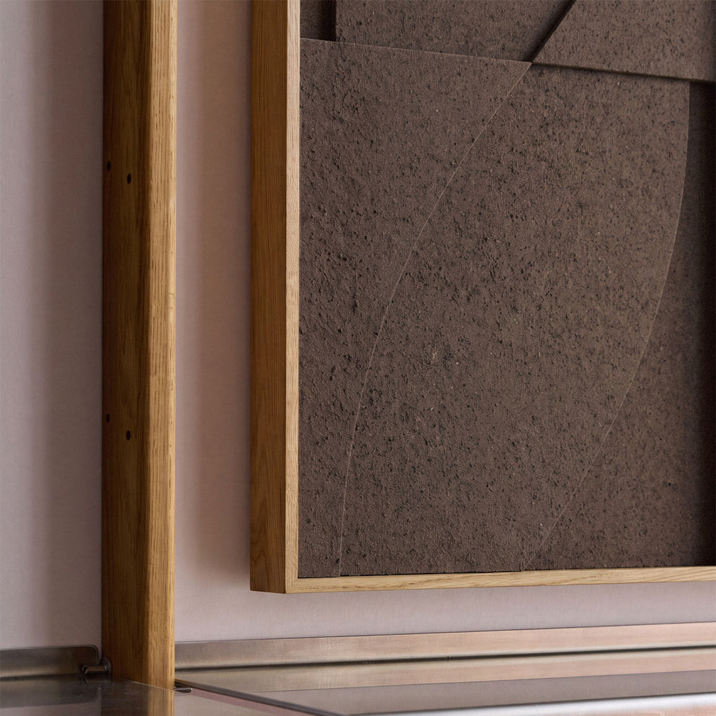 Close up of a medium sized textile acoustic artwork in dark brown color with an oak frame.