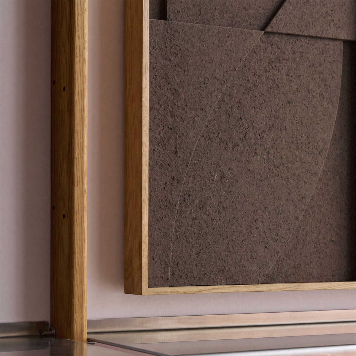 Close up of a medium sized textile acoustic artwork in dark brown color with an oak frame.