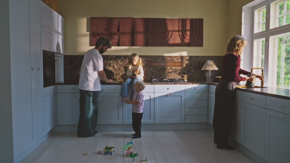 Family of four in a kitchen with 4 acoustic panels on the wall.